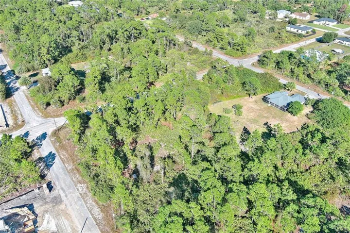 Aerial view of property and surrounding area with a heavily wooded area