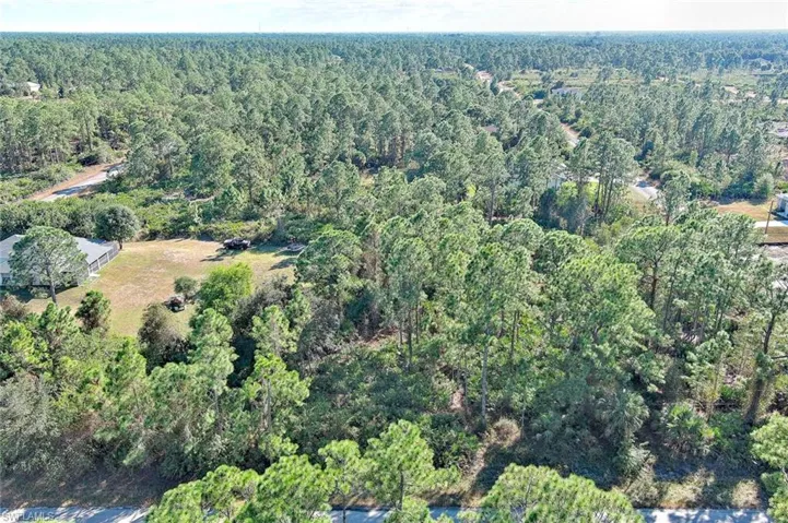 Aerial view of property's location with a heavily wooded area
