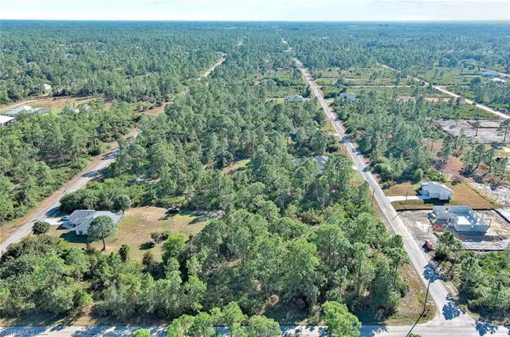 Aerial overview of property's location with a heavily wooded area