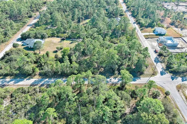 Aerial view of property and surrounding area featuring a forest