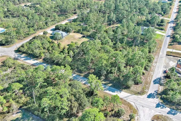 Aerial view of property and surrounding area with a heavily wooded area