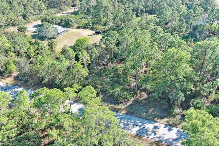 Aerial view of property and surrounding area featuring a heavily wooded area