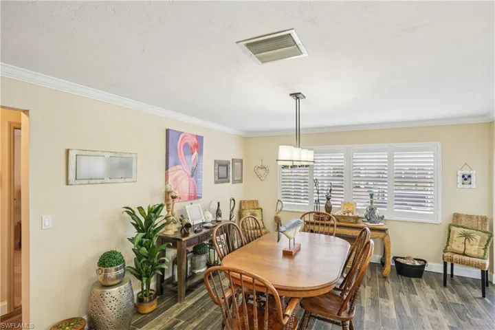 Dining space featuring dark wood finished floors and crown molding
