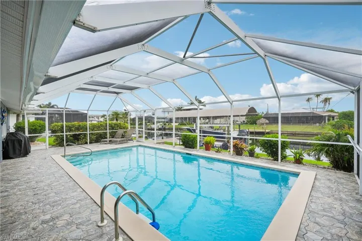 Swimming pool featuring a lanai, a grill, and a patio area