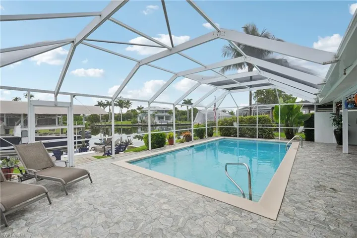 Swimming pool featuring a patio area and glass enclosure