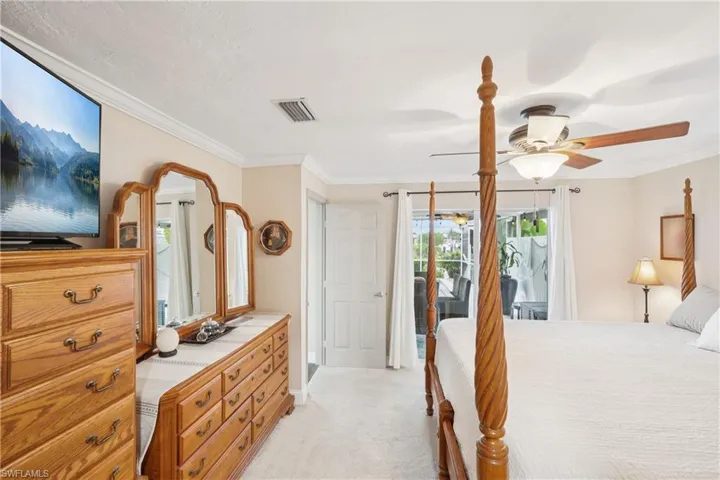 Bedroom featuring ornamental molding, light carpet, access to outside, and ceiling fan