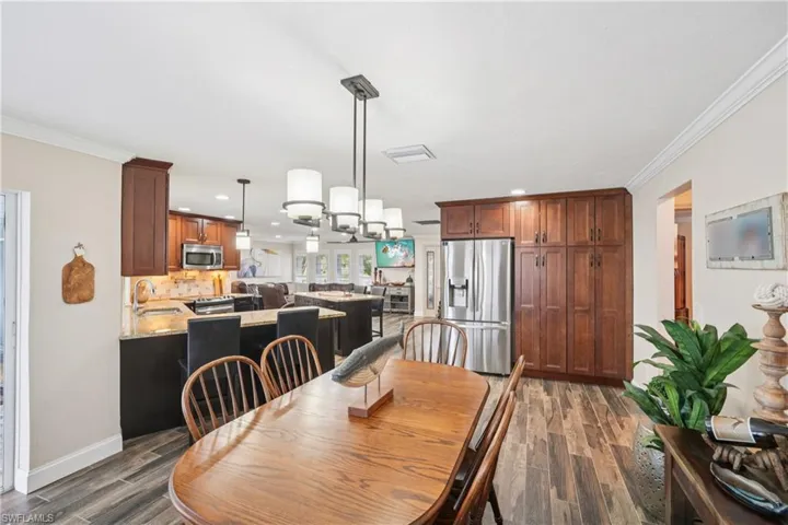 Dining room featuring recessed lighting, dark wood-style flooring, and ornamental molding