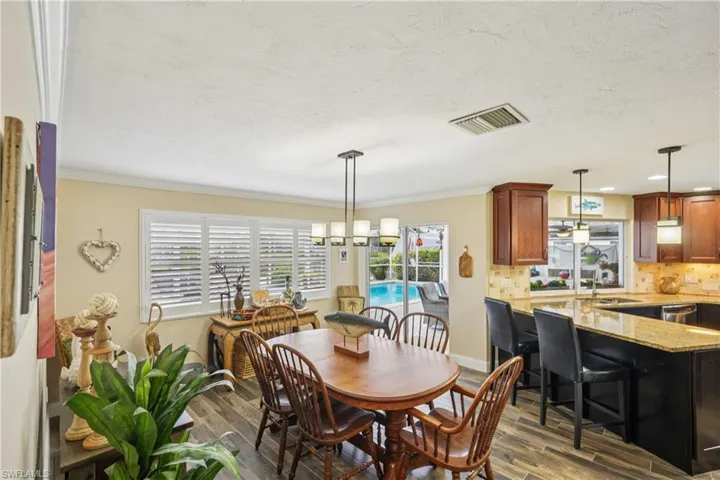 Dining space with wood finished floors and ornamental molding