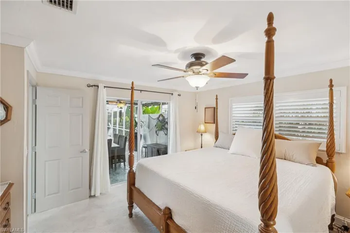 Bedroom with access to outside, ornamental molding, a ceiling fan, and light carpet