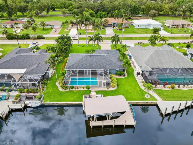 Aerial view of residential area with a pool and a large body of water