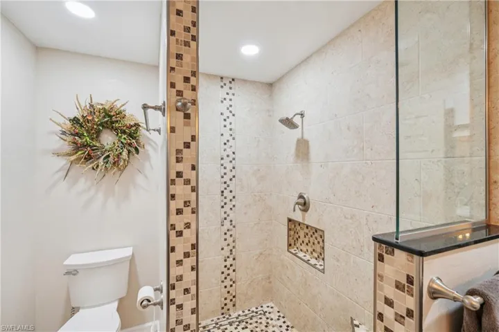 Full bath featuring tiled shower and recessed lighting