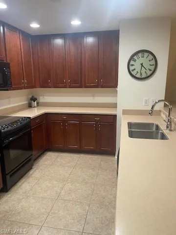 Kitchen featuring black appliances, light tile patterned floors, and recessed lighting