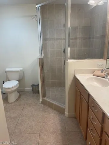 Bathroom with vanity, a stall shower, and light tile patterned flooring