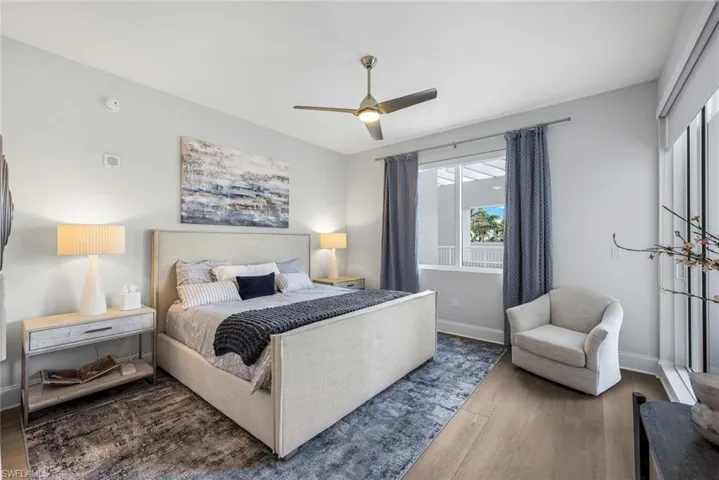 Guest bedroom with lanai access, en suite bath and wood flooring.