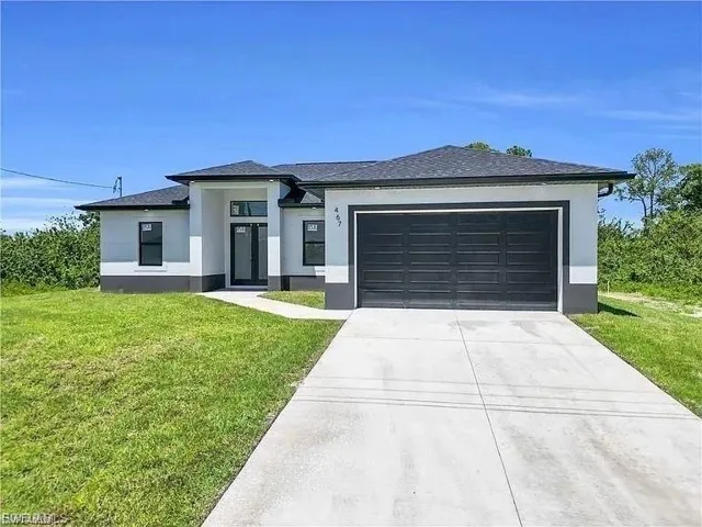 Contemporary exterior featuring a charcoal garage door, black-framed windows, and a covered entry