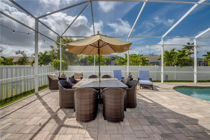 Fenced backyard featuring a sunroom, an outdoor pool, glass enclosure, and a patio