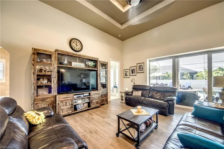 Living room with a high ceiling, light wood-style floors, and arched walkways