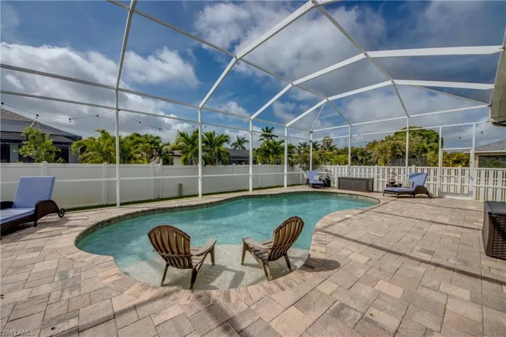 View of swimming pool featuring a fenced backyard, a lanai, a sunroom, and patio surround