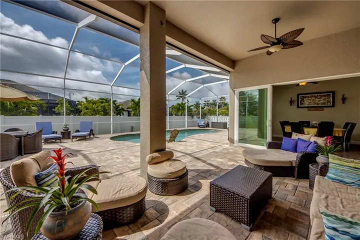 Fenced backyard featuring an outdoor living space, a patio, a sunroom, a lanai, and a ceiling fan