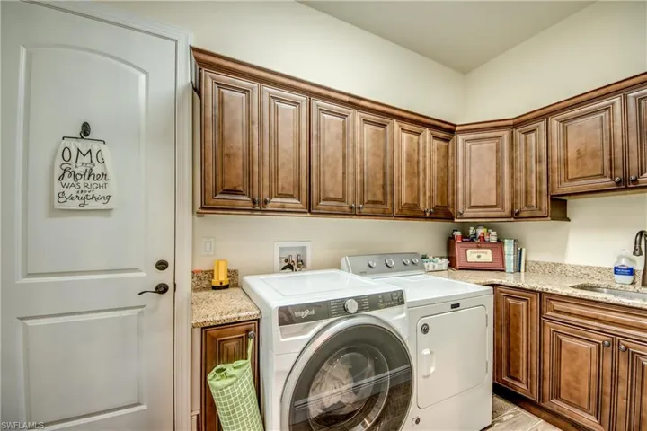Laundry area featuring separate washer and dryer and cabinet space
