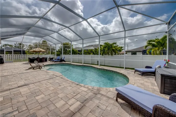 View of pool with an outdoor living space, a fenced backyard, a sunroom, and a lanai