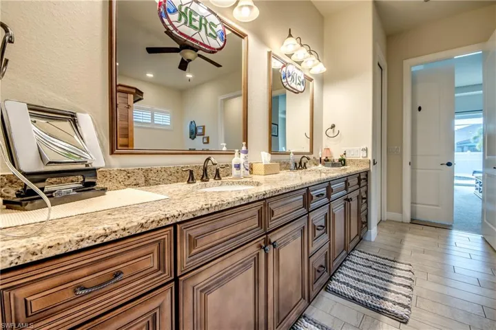 Bathroom with double vanity and ceiling fan