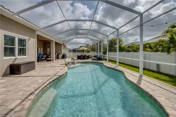 View of swimming pool with outdoor lounge area, patio surround, a sunroom, a fenced backyard, and a lanai