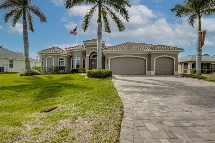 Mediterranean / spanish house with decorative driveway, an attached garage, stucco siding, and a tile roof
