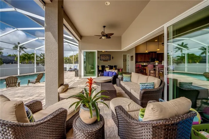View of patio featuring an outdoor living space, glass enclosure, a sunroom, and a ceiling fan