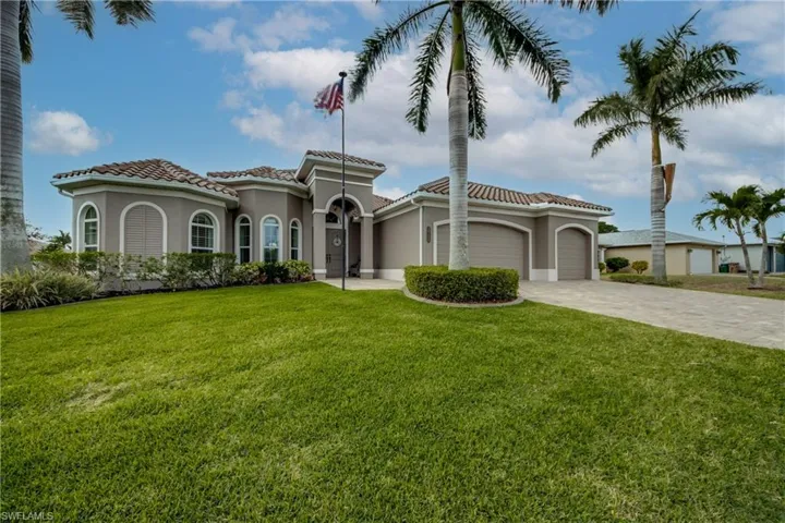 Mediterranean / spanish-style home with stucco siding, an attached garage, decorative driveway, a front lawn, and a tiled roof