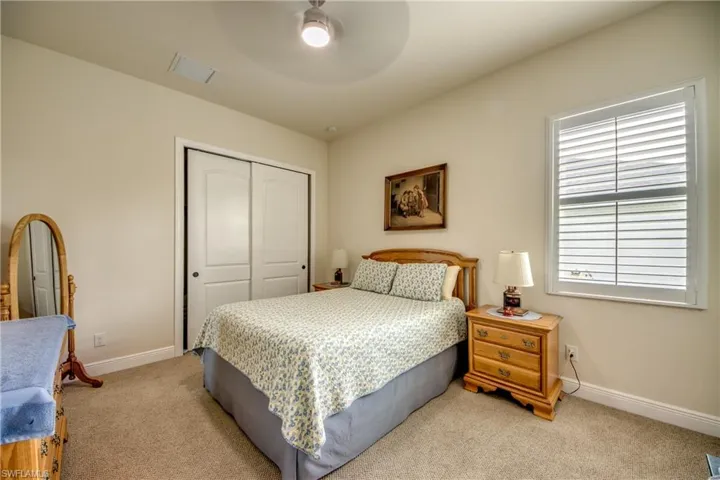 Carpeted bedroom with a closet and a ceiling fan