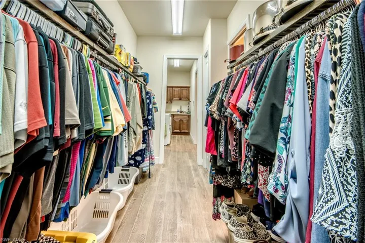 Walk in closet with light wood finished floors