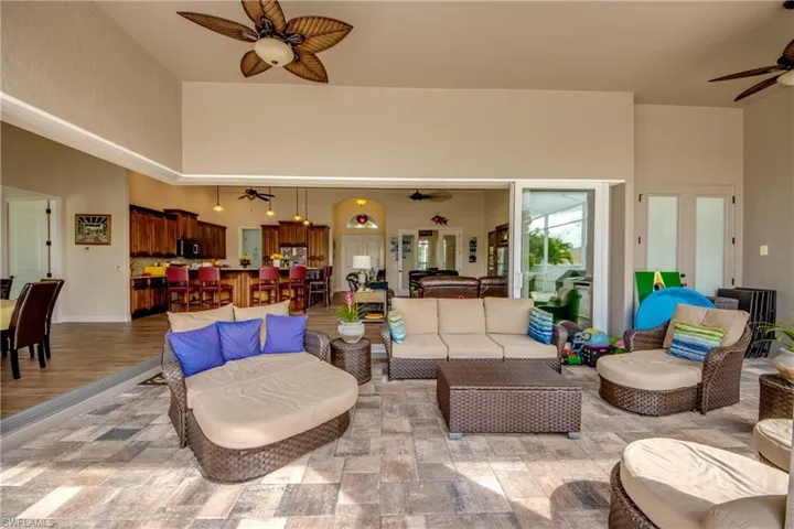 Living room featuring a ceiling fan and a high ceiling