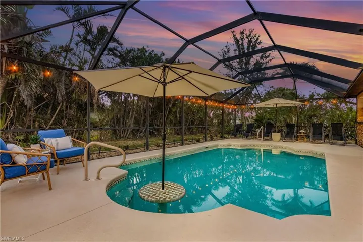 Pool at dusk featuring a lanai and a patio area