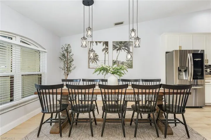 Dining room featuring light wood-type flooring and lofted ceiling