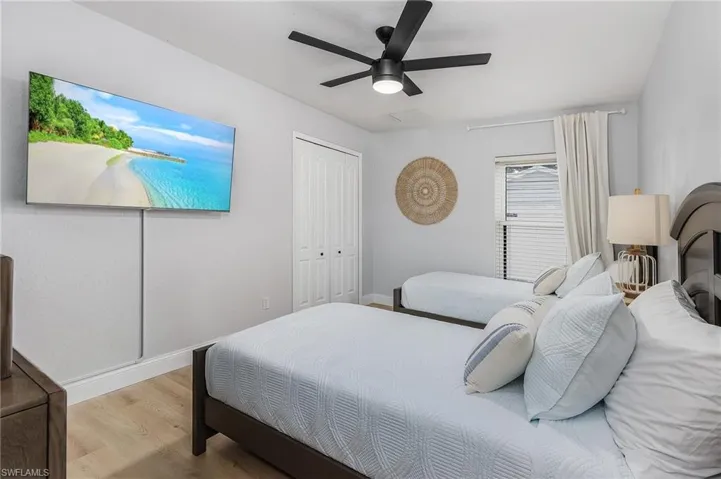 Bedroom with ceiling fan, light hardwood / wood-style flooring, and a closet