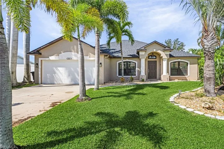 View of front of home with a garage and a front lawn