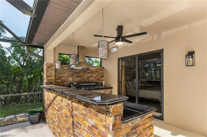 View of patio featuring area for grilling and ceiling fan