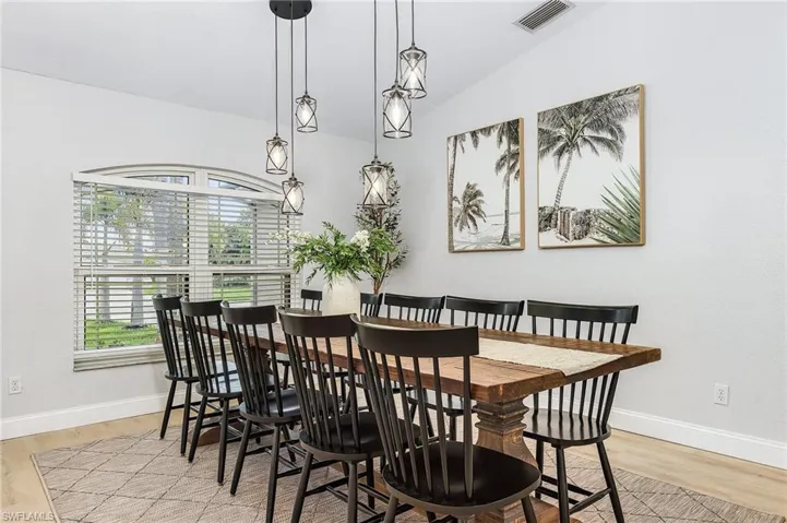 Dining room featuring light wood-type flooring and vaulted ceiling