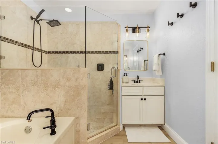 Bathroom with wood-type flooring, independent shower and bath, and vanity