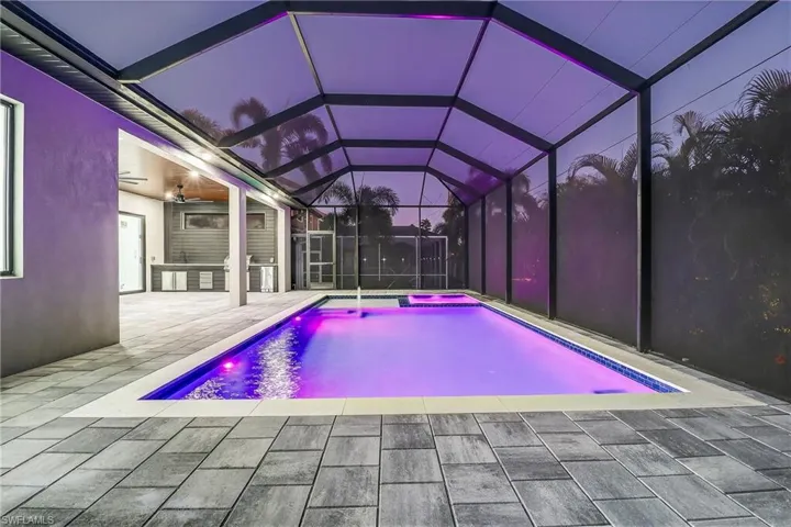 Outdoor pool featuring a lanai, an in-ground hot tub and a patio area