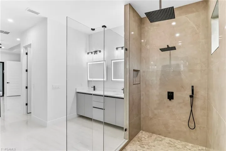Bathroom featuring double vanity and a luxury finished shower