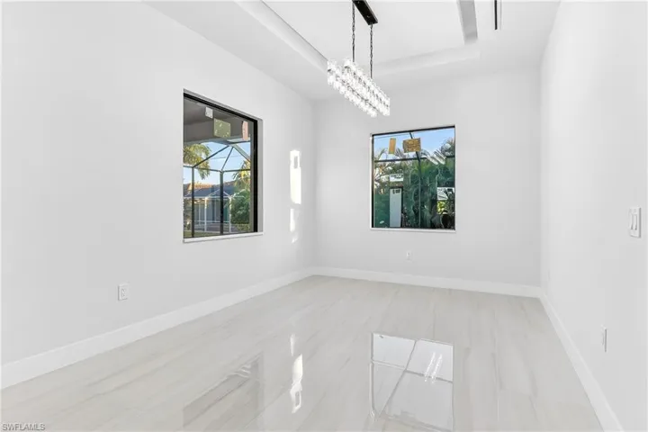 dining room with suspended lighting and a raised ceiling