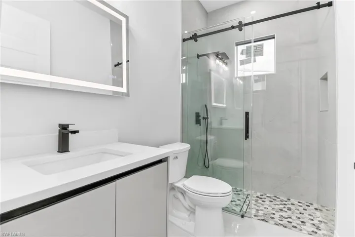 Full bathroom with luxury tile finish shower and quartz vanity