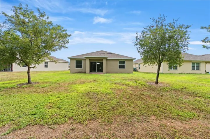View of front of property with a front yard and stucco siding