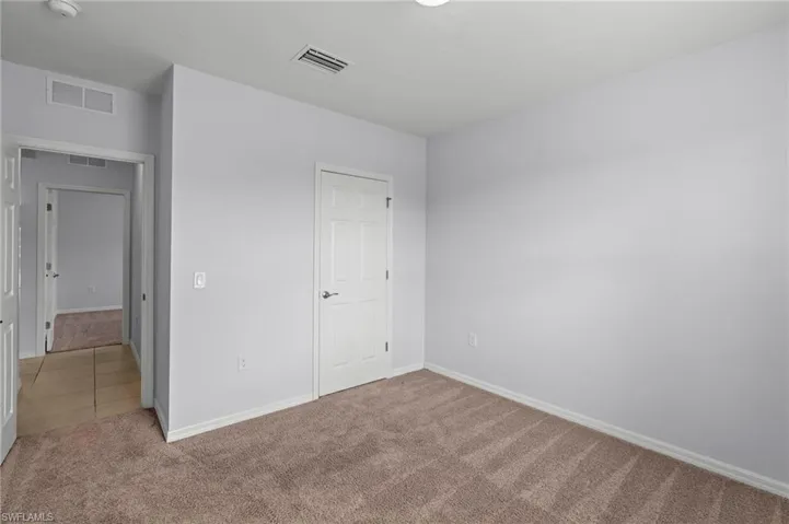 Unfurnished bedroom with carpet floors and baseboards