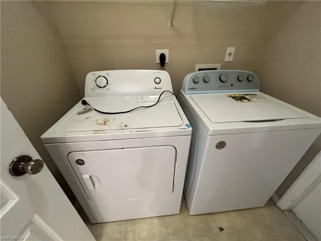 Laundry area featuring washing machine and clothes dryer and light wood-style floors