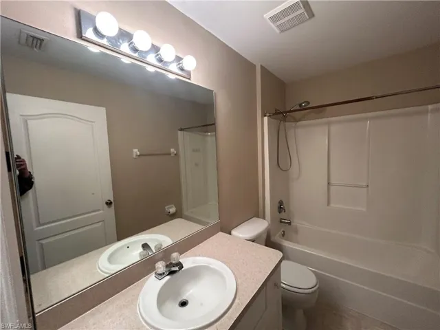 Bathroom with vanity, shower / tub combination, and tile patterned floors