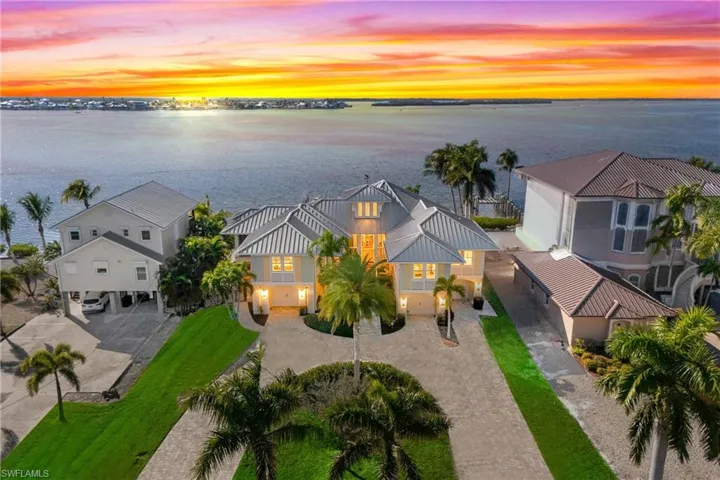 Curb appeal alert!  Large circular paved driveway welcomes you to this STUNNING 3 bedrooms and a den, 5 bathrooms, and split 4 car garage!  Endless views of sunsets and a dream waterfront lot!