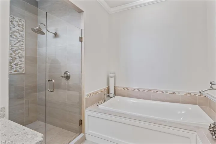 Large walk in shower with built in bench and a beautiful private window out to the water.  Separate tub is perfect to relax and enjoy!